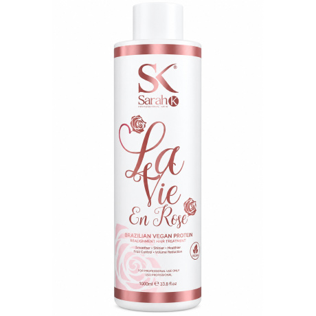 Sarah K Professional Hair La Vie en Rose Brazilian Vegan Protein is een professionele gladmakende en verzorgende behandeling voor haar dat pluizig, volumineus, droog of moeilijk handelbaar is. De behandeling helpt de haarvezel gladder en zachter te maken, vermindert ongewenst volume en geeft het haar meer glans en controle. 1. Analyseer het haar Controleer vóór de behandeling altijd de conditie van het haar. Let op porositeit, elasticiteit, dikte, eerdere kleuringen, ontkleuringen en andere chemische behandelingen. Voer bij blond, geblondeerd, poreus, beschadigd of chemisch behandeld haar altijd eerst een pluktest uit. Wanneer het haar extreem elastisch, breekbaar of sterk beschadigd is, wordt aangeraden de behandeling uit te stellen. 2. Haar voorbereiden Was het haar grondig met een diep reinigende of clarifying shampoo zodat resten van stylingproducten, talg en andere ophopingen worden verwijderd. Bij veel productopbouw kan het haar indien nodig tweemaal worden gewassen. Gebruik vóór de behandeling geen conditioner of zwaar masker. Spoel het haar goed uit en verwijder overtollig water. 3. Haar verdelen Droog het haar indien nodig gedeeltelijk en verdeel het vervolgens in vier tot zes werkzones. Werk steeds met kleine, dunne lokken. Dit zorgt voor een gelijkmatige verdeling van het product en een beter eindresultaat. 4. La Vie en Rose Brazilian Vegan Protein aanbrengen Draag professionele beschermende handschoenen. Breng het product lok voor lok aan en blijf ongeveer 1 cm van de hoofdhuid verwijderd. Verdeel de Brazilian Vegan Protein gelijkmatig over de lengtes en punten. Kam iedere lok zorgvuldig door met een fijne kam zodat overtollig product wordt verwijderd. Het haar moet goed bedekt zijn, maar hoeft niet zwaar verzadigd te zijn. 5. Inwerktijd Laat het product ongeveer 40 tot 45 minuten inwerken. Bij fijn, poreus of sterk chemisch behandeld haar moet de conditie regelmatig worden gecontroleerd. De exacte inwerktijd kan worden aangepast aan de weerstand en structuur van het haar. 6. Uitspoelen Spoel na de inwerktijd het overtollige product zorgvuldig uit met water. Gebruik tijdens deze stap geen shampoo. Spoel gelijkmatig zodat er geen zware productophoping in het haar achterblijft. 7. Haar volledig föhnen Föhn het haar daarna volledig droog. Het haar moet vóór het gebruik van de stijltang 100% droog zijn. Föhn het haar zo glad mogelijk in de gewenste richting. Hierdoor is tijdens het sealen minder onnodige hitte nodig. 8. Temperatuur van de stijltang De temperatuur moet altijd worden aangepast aan de conditie van het haar. Als professionele richtlijn kan worden gewerkt met ongeveer 170–180°C bij zeer gevoelig, poreus of sterk geblondeerd haar, 180–200°C bij fijn, gekleurd of chemisch behandeld haar, 200–220°C bij normaal en gezond haar en maximaal ongeveer 220–230°C bij dik, sterk en zeer resistent natuurlijk haar. Gebruik bij twijfel altijd eerst een lagere temperatuur. 9. Sealen met de stijltang Verdeel het volledig droge haar opnieuw in kleine zones. Neem zeer dunne lokken en werk systematisch vanaf de nek naar boven. Ga gecontroleerd met de stijltang over iedere lok. Het aantal passages moet worden aangepast aan de conditie van het haar. Gezond en resistent haar kan meer passages verdragen dan fijn, blond, poreus of chemisch behandeld haar. Werk bij gevoelige lengtes en punten altijd met minder warmte en minder passages. Blijf nooit met de stijltang stilstaan op één plaats. Extra belangrijk bij blond en beschadigd haar Werk bij blond, geblondeerd of zeer poreus haar nooit automatisch op de maximale temperatuur. Begin met een lagere temperatuur en controleer voortdurend hoe de haarvezel reageert. Wanneer het haar tekenen van overmatige elasticiteit, breuk of verzwakking vertoont, moet de behandeling worden gestopt. Resultaat Bij een correcte professionele toepassing wordt het haar gladder, zachter en beter handelbaar. Pluis en ongewenst volume worden verminderd en het haar krijgt meer glans en een verzorgde uitstraling. Het uiteindelijke resultaat is afhankelijk van het oorspronkelijke haartype, de conditie van het haar, de gebruikte temperatuur en de applicatietechniek. Onderhoud na de behandeling Gebruik na de behandeling bij voorkeur een milde professionele shampoo en conditioner voor behandeld haar. Vermijd agressief reinigende shampoos wanneer u het resultaat zo lang mogelijk wilt behouden. Een hydraterend of voedend masker kan regelmatig worden gebruikt om de zachtheid, soepelheid en glans van het haar te ondersteunen. Voorzorgsmaatregelen Uitsluitend voor professioneel gebruik. Voer vóór gebruik een pluktest uit. Gebruik beschermende handschoenen en werk in een goed geventileerde ruimte. Vermijd contact met de hoofdhuid, ogen en slijmvliezen. Niet gebruiken op een geïrriteerde of beschadigde hoofdhuid. Bij contact met de ogen onmiddellijk overvloedig met water spoelen. Niet gebruiken op extreem beschadigd of sterk breekbaar haar. Buiten bereik van kinderen bewaren en beschermen tegen direct zonlicht en overmatige warmte. Volg bij afwijkende instructies altijd de aanwijzingen op de originele verpakking van Sarah K Professional Hair.