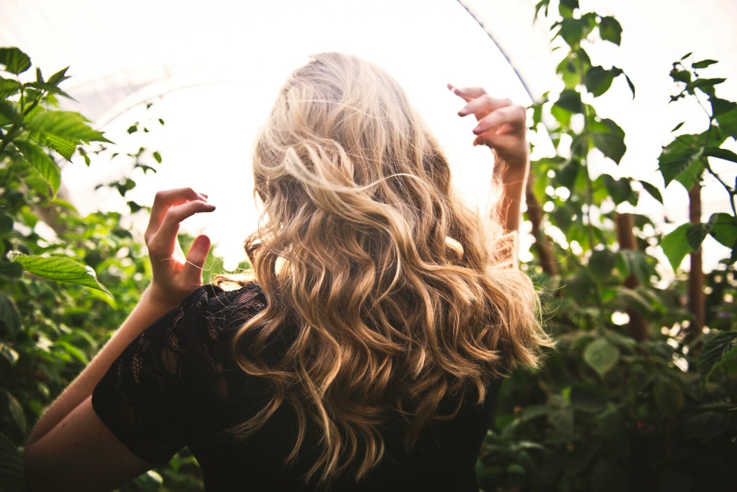 Vrouw met blond haar tussen planten