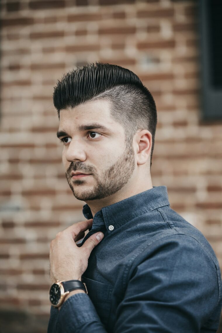 Man met strak gestyled haar in zwart overhemd